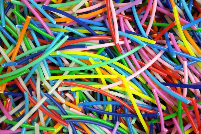 Close-up view illustrating PLA pellets being fed into an extruder vs. traditional filament spool