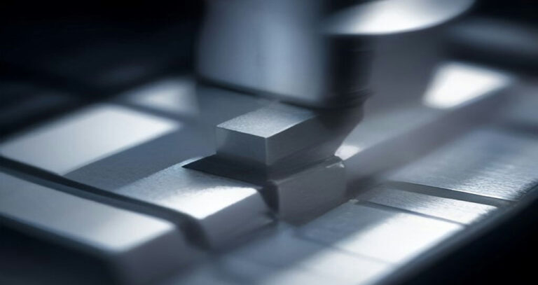 CNC Machine That Cuts Metal — Close-up of a carbide end mill cutting an aluminum block, metal chips flying