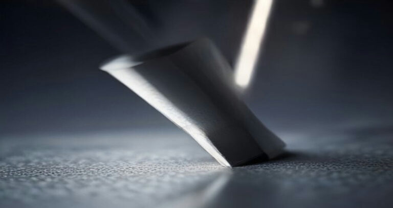Computer Numerical Control CNC Machines — Close-up of a carbide end mill cutting aluminum, chips flying, blurred shop background
